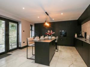 a kitchen with black walls and a island in the middle at 2 Manorhouse Farm in Rochdale