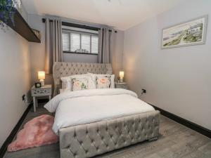 a bedroom with a large bed and a window at 2 Manorhouse Farm in Rochdale