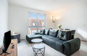 a living room with a couch and a tv at Dom Central Suite in Greifswald