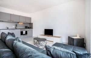 a living room with a couch and a kitchen at Dom Central Suite in Greifswald