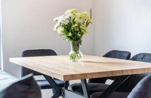 a vase of flowers sitting on top of a wooden table at Dom Central Suite in Greifswald