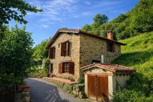 a small stone house on a road at El Refugio de Redo - balcón a los Picos de Europa in Camaleño