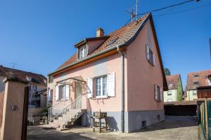an old house with a staircase in a street at Gîte Bretzel et Grappe in Ingersheim