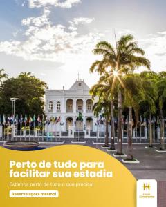 a white building with palm trees in front of it at HOTEL LIVRAMENTO Maceió in Maceió