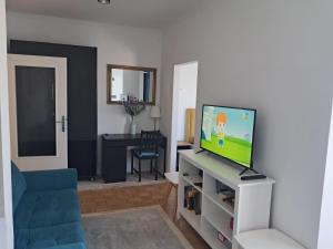 a living room with a tv and a blue couch at Apartman Čuić in Vinkovci