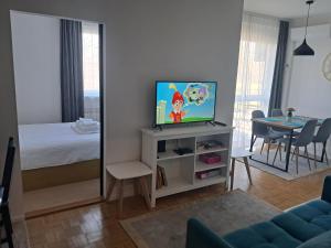 a living room with a tv and a bedroom at Apartman Čuić in Vinkovci +7 photos