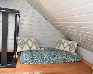 a bed in a tiny house with two pillows at La petite maison en Ardenne in Marche-en-Famenne
