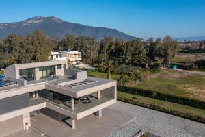 a white house with a view of a mountain at Sun and Sea Apartment - Beachfront, 2 Bedrooms with Sea View & Garden in Paralio Astros