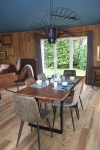 a dining room with a wooden table and chairs at La petite maison en Ardenne in Marche-en-Famenne