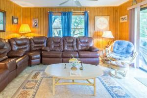 a living room with brown leather furniture and a table at 7602 - Drydock in Avon
