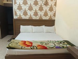 a bedroom with a bed with a blanket on it at hotel atithi palace in Jabalpur