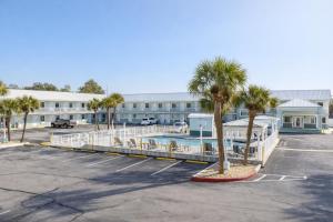 a parking lot in front of a building with a pool at Destin Inn & Suites in Destin
