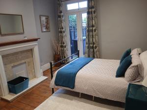a bedroom with a bed with a fireplace and a window at Spacious 4 Bedroom House, Garden, Nr Ipswich Town Centre with hot tub in Ipswich