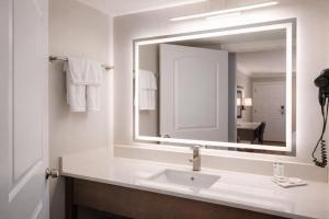 a bathroom with a sink and a large mirror at Destin Inn & Suites in Destin +19 photos