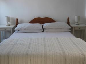 a bedroom with a large bed with two night stands at Trezise Cottage in Penzance