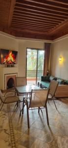 a living room with a table and chairs and a fireplace at Chic Palm Grove Apartment Pool View in Marrakesh