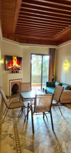 a living room with a table and a fireplace at Chic Palm Grove Apartment Pool View in Marrakesh