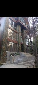 a large building with stairs in front of it at Pine Breeze Luxe in Gulmarg