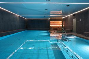 an indoor swimming pool with blue lights on the ceiling at Hotel Reśliński in Grodzisk Wielkopolski