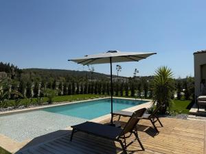 a chair and an umbrella next to a swimming pool at Kırmızı Bağ Resort in Kuscular