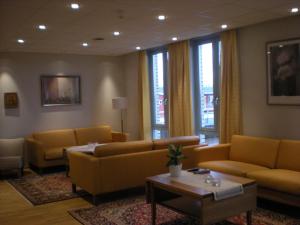 a living room with yellow couches and a table at Birgittaklosteret i Trondheim in Trondheim