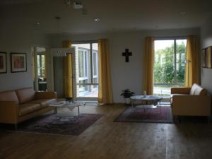 a living room with two couches and a cross on the wall at Birgittaklosteret i Trondheim in Trondheim +1 photo