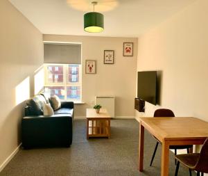 a living room with a couch and a table at 1BR Flat By Cozy Quarters Property Management Short Term Rental Hartlepool Near Marina Views in Hartlepool