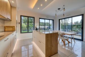 a kitchen with a dining area and a table with chairs at Le Jardin de Lili - Disney 30 min - Clim & Wifi in Germigny-lʼEvêque
