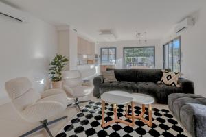 a living room with a couch and chairs at Le Jardin de Lili - Disney 30 min - Clim & Wifi in Germigny-lʼEvêque