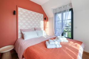 a bedroom with a bed with towels on it at Le Jardin de Lili - Disney 30 min - Clim & Wifi in Germigny-lʼEvêque