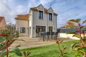 a house with a patio and lawn with chairs at Le Jardin de Lili - Disney 30 min - Clim & Wifi in Germigny-lʼEvêque