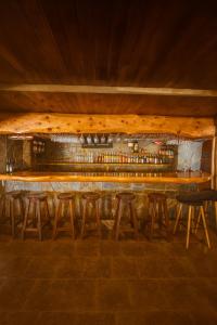 a bar with stools and a wooden counter top at Hosteria Iloca in Iloca