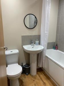 a bathroom with a toilet and a sink and a mirror at 1BR Flat By Cozy Quarters Property Management Short Term Rental Hartlepool Near Marina Views in Hartlepool