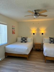 a bedroom with two beds and a ceiling fan at Sea Breeze Inn in Edgewater