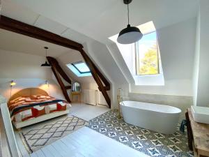 a bathroom with a bed and a tub in a room at Maison Loire et Mer in Mer