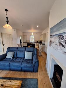 a living room with a blue couch and a fireplace at Doolin Court in Doolin