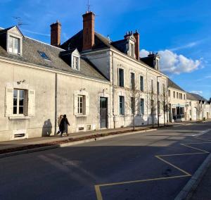 two people walking down a street next to a building at Maison Loire et Mer in Mer