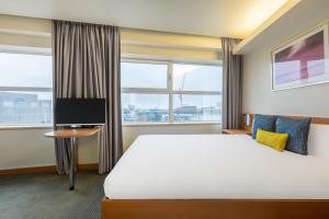a hotel room with a bed and a tv at STG Hotel Oxford Street - formerly St Giles London Hotel in London