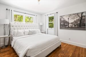 a white bedroom with a large bed and two windows at BlackBerry - Private home with Jacuzzi year-around in East Hampton