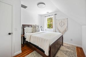 a white bedroom with a bed and a window at BlackBerry - Private home with Jacuzzi year-around in East Hampton
