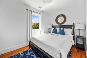 a white bedroom with a large bed and a window at BlackBerry - Private home with Jacuzzi year-around in East Hampton