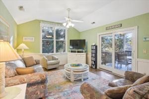 a living room with a couch and a tv at 4620 - Flip Flop Inn in Southern Shores