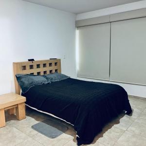 a bedroom with a bed and a wooden headboard at Cuarto con linda vista in Hércules