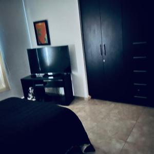a bedroom with a bed and a flat screen tv at Cuarto con linda vista in Hércules