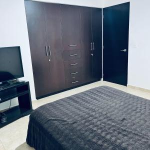 a bedroom with a bed and cabinets and a television at Cuarto con linda vista in Hércules