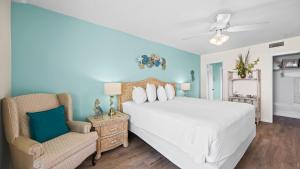 a bedroom with a white bed and a chair at Romar Tower 5C in Romar Beach +46 photos