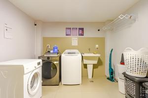 a laundry room with a washing machine and a sink at Studio IV Jundiaí - Com Ar Condicionado in Jundiaí