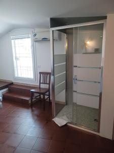 a room with a glass shower and a chair at Hotel Villa Pagoda in Sirmione +55 photos