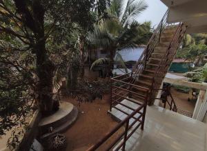 a stairway leading to a balcony with a tree at House 21 - Mid in Querim
