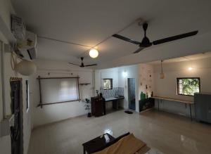 an empty living room with a projection screen and ceiling fans at House 21 - Mid in Querim